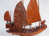 une maquette en bois d'un bateau aux voiles rouges