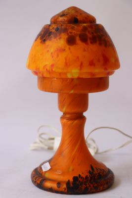une lampe en forme de champignon orange posée sur une table blanche