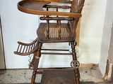 a wooden high chair with a tray on top of it