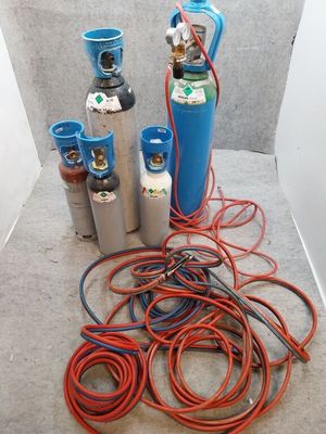 de nombreux types de bouteilles de gaz et de tuyaux éparpillés sur le sol