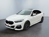 une BMW M140i break sportive blanche garée dans une pièce blanche