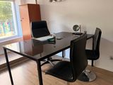a black table with two chairs and a laptop on top of it