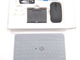 a box with a keyboard, mouse, mouse pad, and other items in it