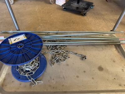 une bobine bleue et une bobine de fil métallique par terre