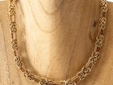 a close up of a mannequin wearing a gold chain necklace
