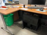 an image of a desk with a computer and a trash can