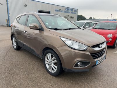 une voiture marron garée sur un parking, avec d'autres voitures en arrière-plan