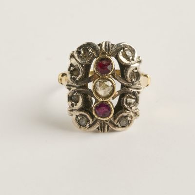 gros plan d'une bague en or avec une pierre rouge au centre