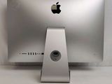 a silver apple computer sitting on a white table