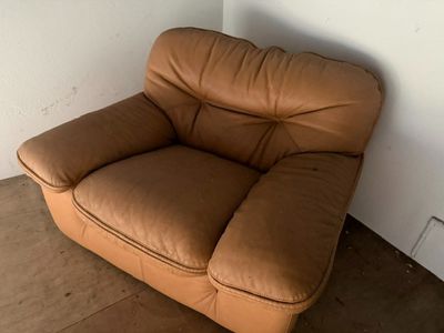 un canapé en cuir marron placé dans un coin de la pièce