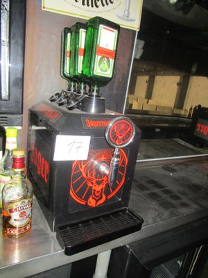 a beer dispenser sitting on a counter next to bottles