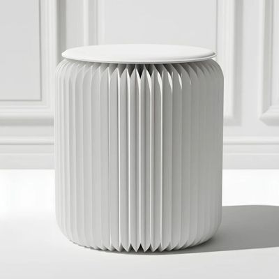 un tabouret blanc sur lequel est posé un papier plié