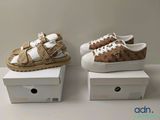 Deux paires de chaussures sont posées sur des cartons, sur une table.