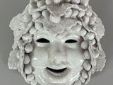 a white mask with a face made of flowers on it