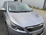 La voiture grise est garée devant un immeuble blanc.