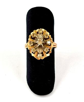 an image of a gold and diamond ring on a black ring holder