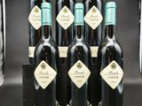 six bouteilles de vin sont alignées sur une table
