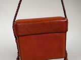 brown leather purse with tassels hanging from it ' s handle