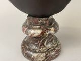 a vase that is sitting on a stand on a table