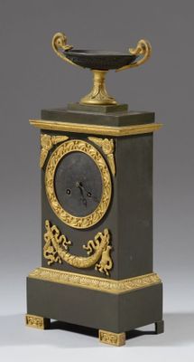 a black and gold clock with a bowl on top of it
