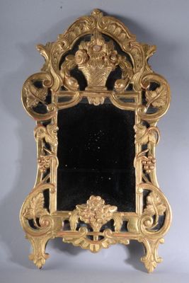 une image représentant un miroir doré posé sur un pied, sur fond noir