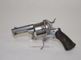 a silver revolver with a black handle on a white surface