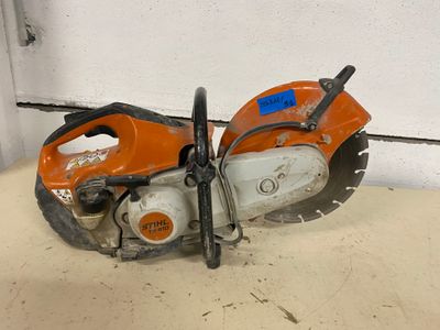 an orange and black chainsaw sitting on top of a table
