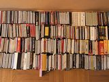 a large pile of dvd ' s on the floor next to a fan