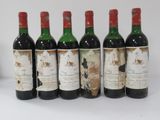 six bottles of wine are lined up on a table