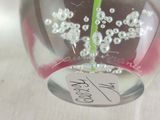a glass vase with a flower inside of it on a table