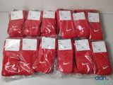 six paires de chaussettes rouges sont emballées dans des sacs en plastique sur une table