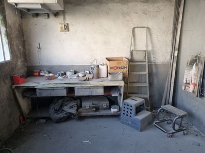 un établi au milieu d'une pièce, sur lequel sont posés des outils