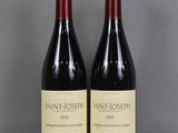 deux bouteilles de vin rouge sont posées l'une à côté de l'autre sur une table