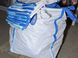 une pile de sacs posée sur une palette dans un garage