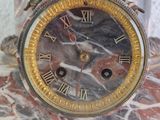 a clock that is sitting on top of a marble table