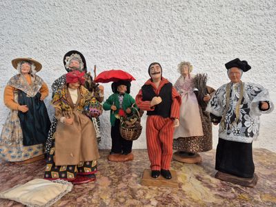 sept figurines représentant des personnes vêtues de costumes différents