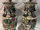 pair of chinese vases with floral designs on them sitting on a white surface