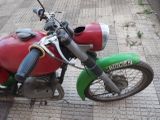 a red and green motorcycle parked on the side of the street