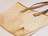 beige leather handbag on white background with brown strap