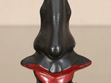 un vase noir au bord rouge posé sur une table en verre