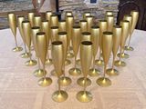 a lot of gold wine glasses sitting on a table