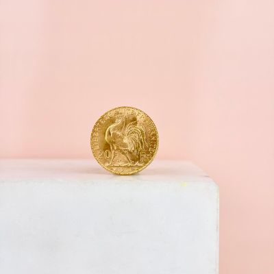 a gold coin sitting on top of a white pedestal