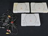 trois consoles de jeux vidéo posées les unes à côté des autres sur une table