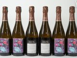 six bouteilles de vin sont alignées sur une table