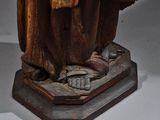 statue of a man in a brown robe holding a book