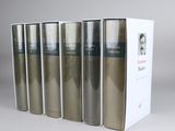 six books in a row on a white surface with a box