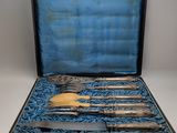 an antique silverware set in a black case with blue velvet lining