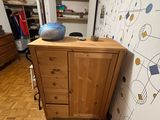 a wooden cabinet with a blue bowl on top of it in the corner of a room