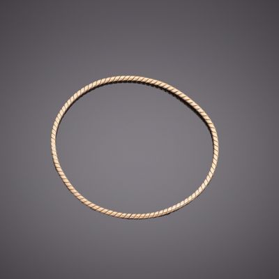 a gold rope bracelet on a gray background
