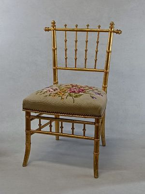 a gold chair with a floral design on the back